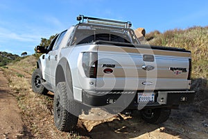 A customized Ford F-150 Raptor SVT on a dirt road