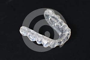 Customized transparent teeth bite guard clear aligners for lower jaw on black background