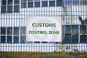 Customs control zone sign on metal fence, border symbol