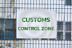 Customs control zone sign on metal fence, border symbol