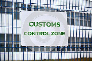 Customs control zone sign on metal fence, border symbol