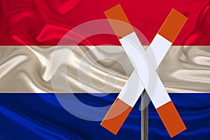 Customs sign, stop, attention against the background of the silk national flag of the country of Netherlands, the concept of