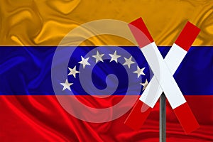 Customs sign, stop, attention on the background of the silk national flag of the country of Venezuela, the concept of border and