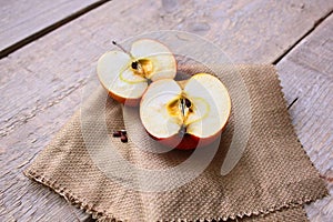 Cut Apple on fabric and wood with flowers and seeds