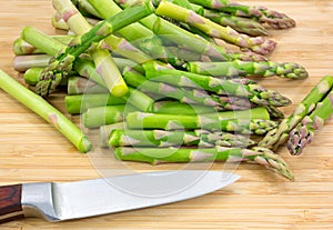 Cut asparagus on cutting board with knife