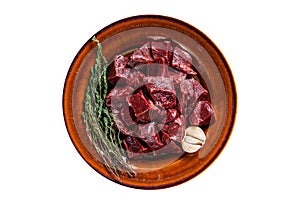 Cut Beef or veal raw heart in a rustic plate with herbs. High quality Isolate, white background.