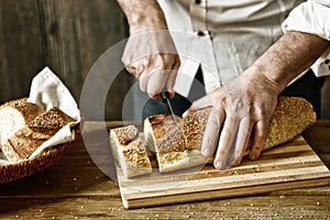 Cut the bread on the wooden cutting board - eat healthy and traditional - selective focus - desaturated effect