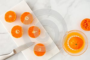 Cut Clementines on Marble Board and Citrus Juicer on Marble