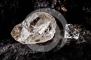 Cut diamond with rough diamond gem on kimberlite rock, on isolated background, diamond business concept