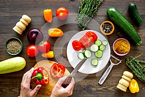 Cut different fresh vegetables on cutting board for cooking vegetable stew. Dark wooden background top view