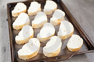 Cut french loaf bread on baking tray