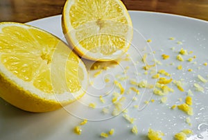 Cut fresh Lemon and peel seen on a dish, ready for a baking ingredient.