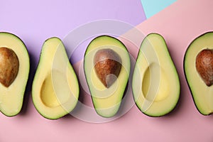 Cut fresh ripe avocados on color background photo