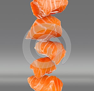 Cut fresh salmon falling on grey background