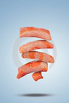 Cut fresh salmon falling on pale light blue gradient background