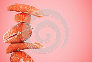 Cut fresh salmon on pink background, space for text
