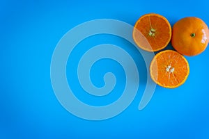 Cut fruit design of orange with desktop on plates blue background. topview or flat lay fruit.