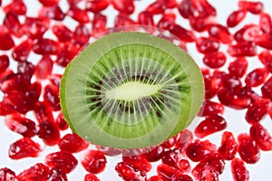 The cut fruit kiwi against garnet grains