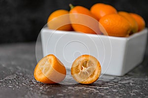 Cut fruit kumquat on a black background