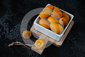 Cut fruit kumquat on a black background, citrus