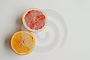 Cut grapefruit and orange halves displayed on white surface