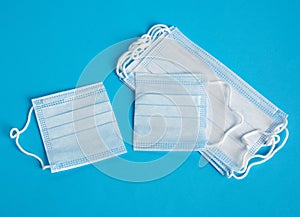 Cut in half disposable medical face mask on blue background