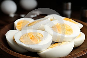 Cut hard boiled chicken eggs in wooden bowl