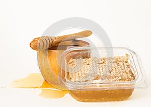 Honeycomb, honey in a wooden bowl and a honey spoon