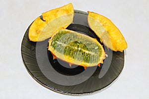 Cut kiwano fruit on plate. Ripe fruit of Cucumis metuliferus. jelly melon