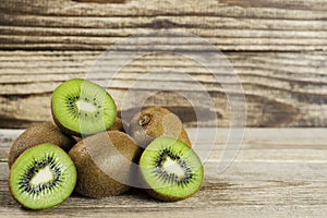 Cut kiwi folded in a pile on a wood background