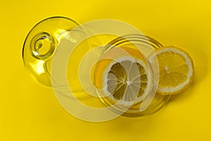 Cut lemon in glassware on yellow  backgroundCopy space photo