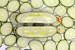 Cut lengthwise the cucumber on the background of sliced cucumber