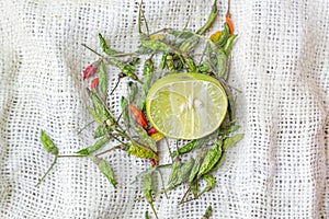 Cut lime and chili on white fabric