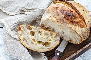 Cut a loaf of artisanal bread on sourdough.