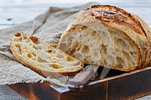 Cut loaf of artisanal wheat bread on sourdough.