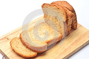 The cut loaf of bread on the wooden cutting board on the white background.