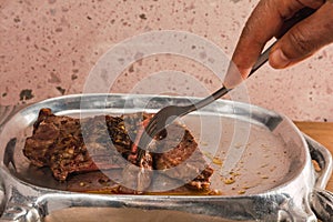 Cut of meat `Aguja norteÃÂ±a Sonora`, served on a silver plate in the shape of a cow photo