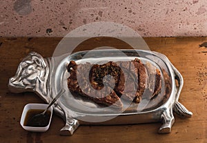 Cut of meat `Aguja norteÃÂ±a Sonora`, served on a silver plate in the shape of a cow 16 photo