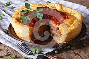 Cut meat pie on a plate close-up. Horizontal