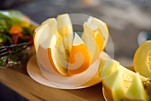 Cut melon on a white plate.