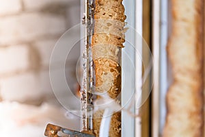 A cut of the old polyurethane foam on a dismantled plastic window. Insulating glass profile photo