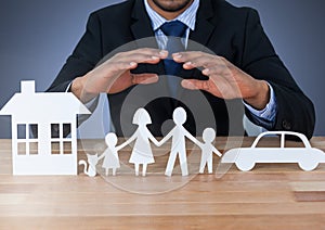 Cut out house family and car under protective hands