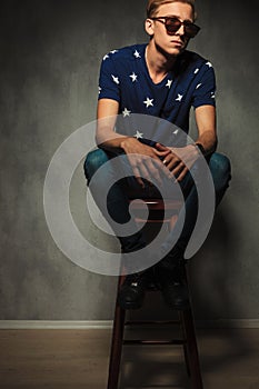 Cut out image of a young fashion man sitting on a stool