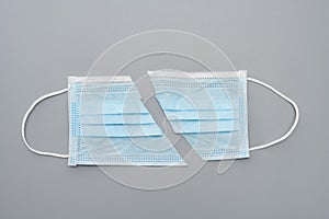 Cut out medical face mask on a grey background concept of fake or useless or invalid mask