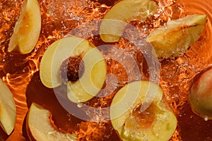 Cut peaches with splashing water on orange
