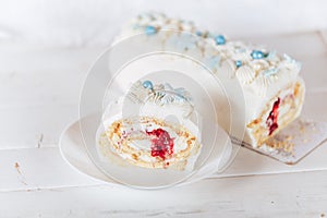 A cut piece from a white roll cake with a cherry filling on against a white background. Christmas mood. Sweets for any