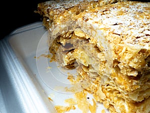 Cut pieces of cake. Napoleon cake close-up. Sweets for tea. A flaky sweet treat. Layer cake. Caloric nutrition