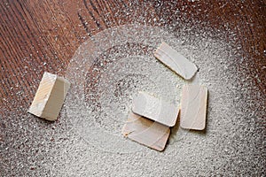 Cut pieces of wood with sawdust on brown wooden floor