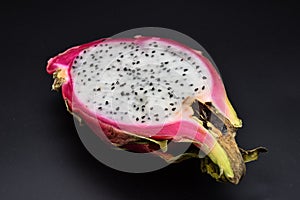 Cut pitahaya on black background close up, cut dragon fruit