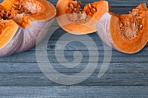 Cut pumpkin slices on gray wooden table with copy space photo
